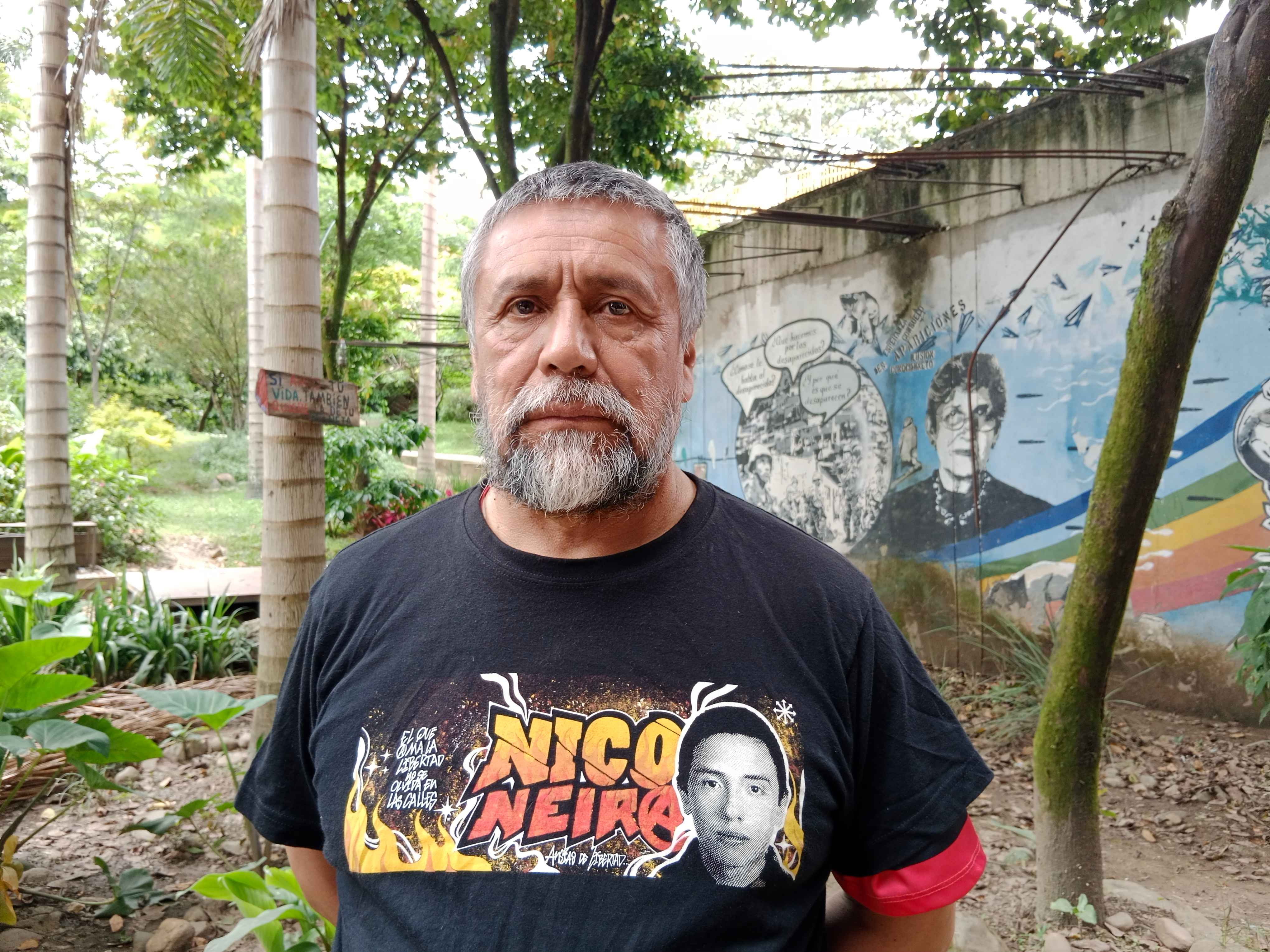 Pie de foto: Yuri Neira en uno de los jardines externos del Museo Casa de la Memoria de Medellín, cerca del mural conmemorativo de Fabiola Lalinde, una madre buscadora. Neira visita vive exiliado en España y visita esporádicamente Colombia.Foto: Karen Parrado Beltrán.