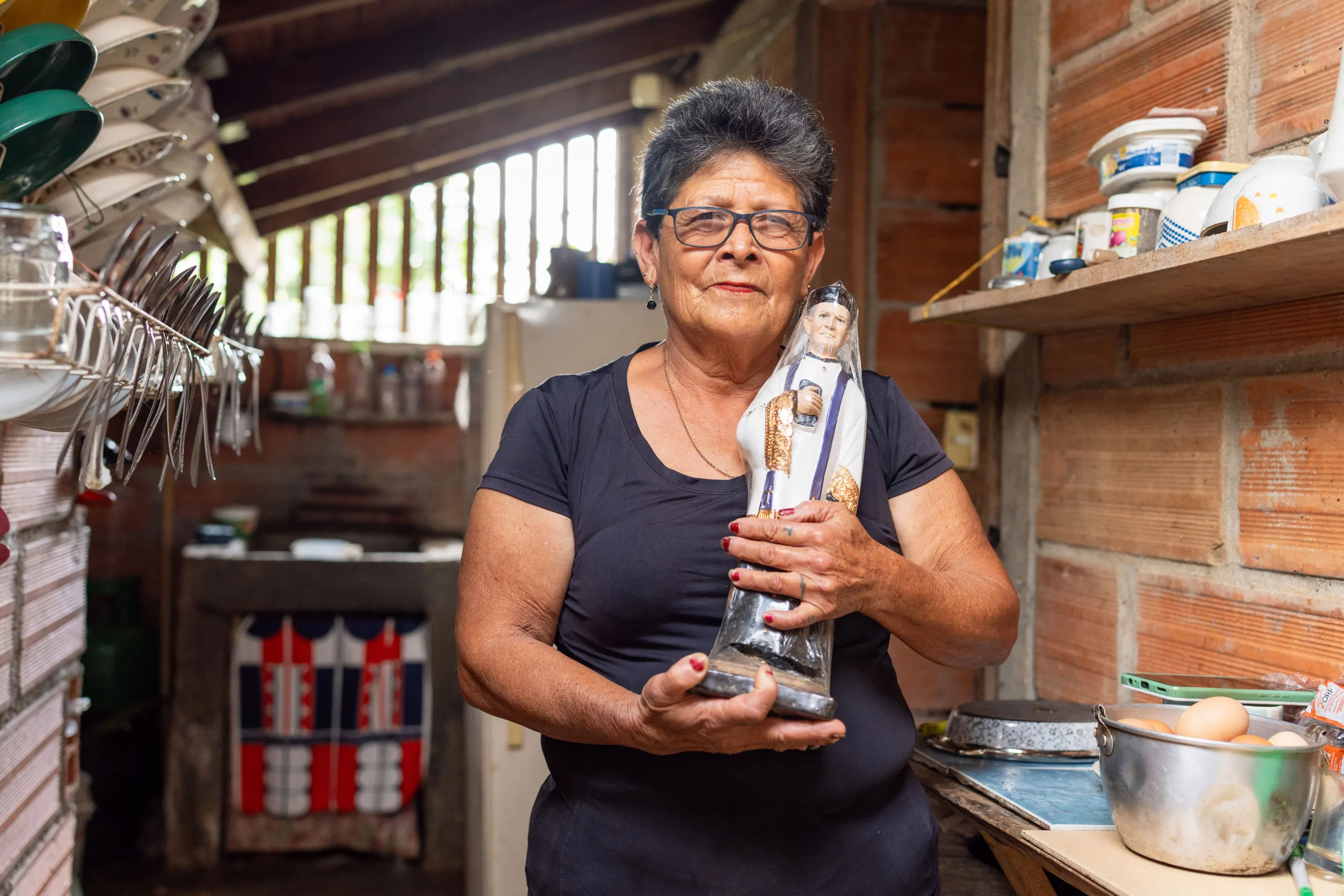 Luz Dary Tobón en su casa de Palocabildo con una figura del Padre Marianito, el santo de su devoción. A él y a la Madre Laura le encomienda la lucha ambiental de su comunidad. Fotografía: Felipe Peláez.