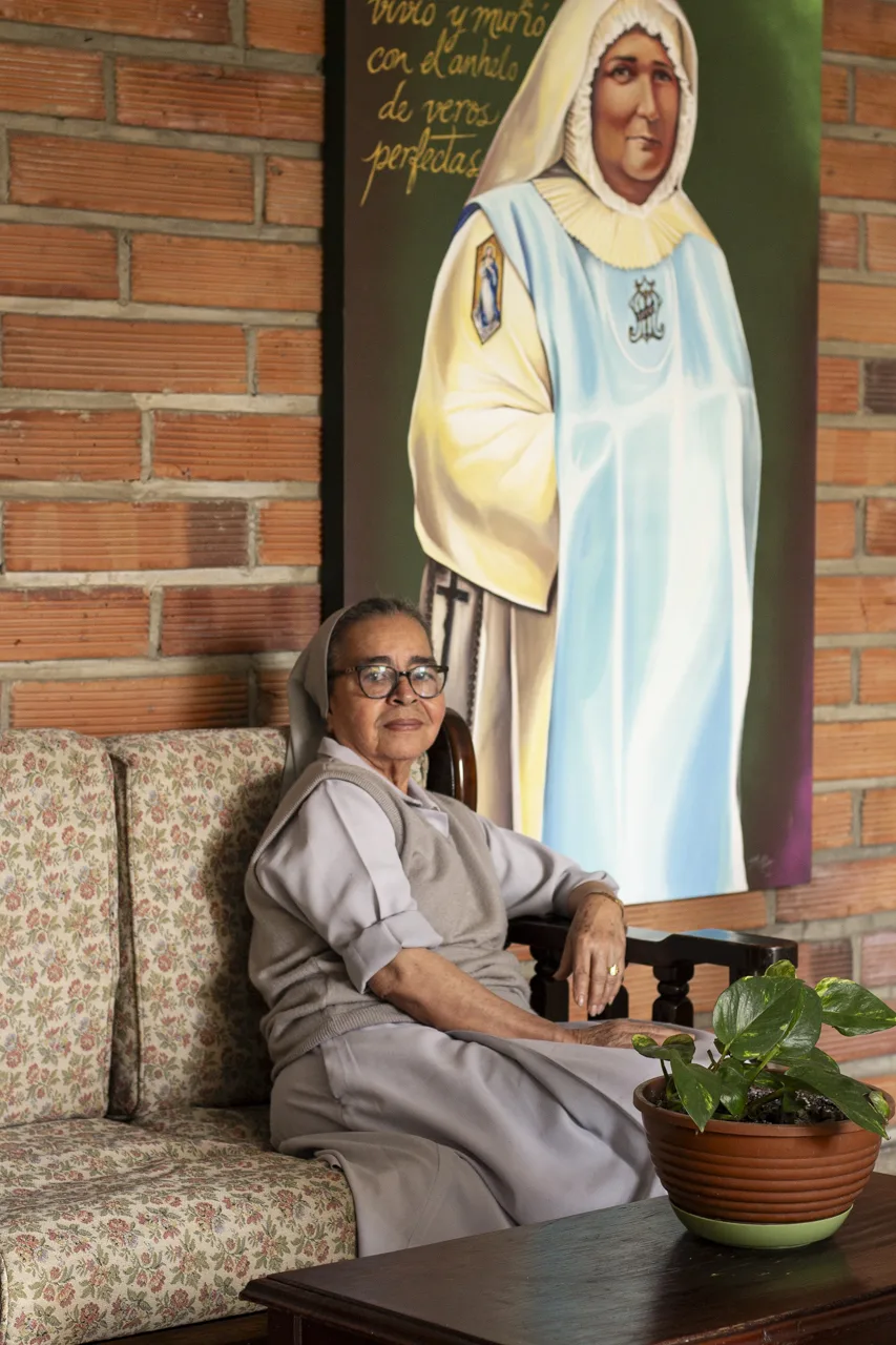 La hermana Elizabeth Rúa junto a un retrato de la Madre Laura, en la casa de retiro de las hermanas mayores de su comunidad religiosa en Medellín, en diciembre de 2025. Fotografía: Karen Parrado Beltrán.