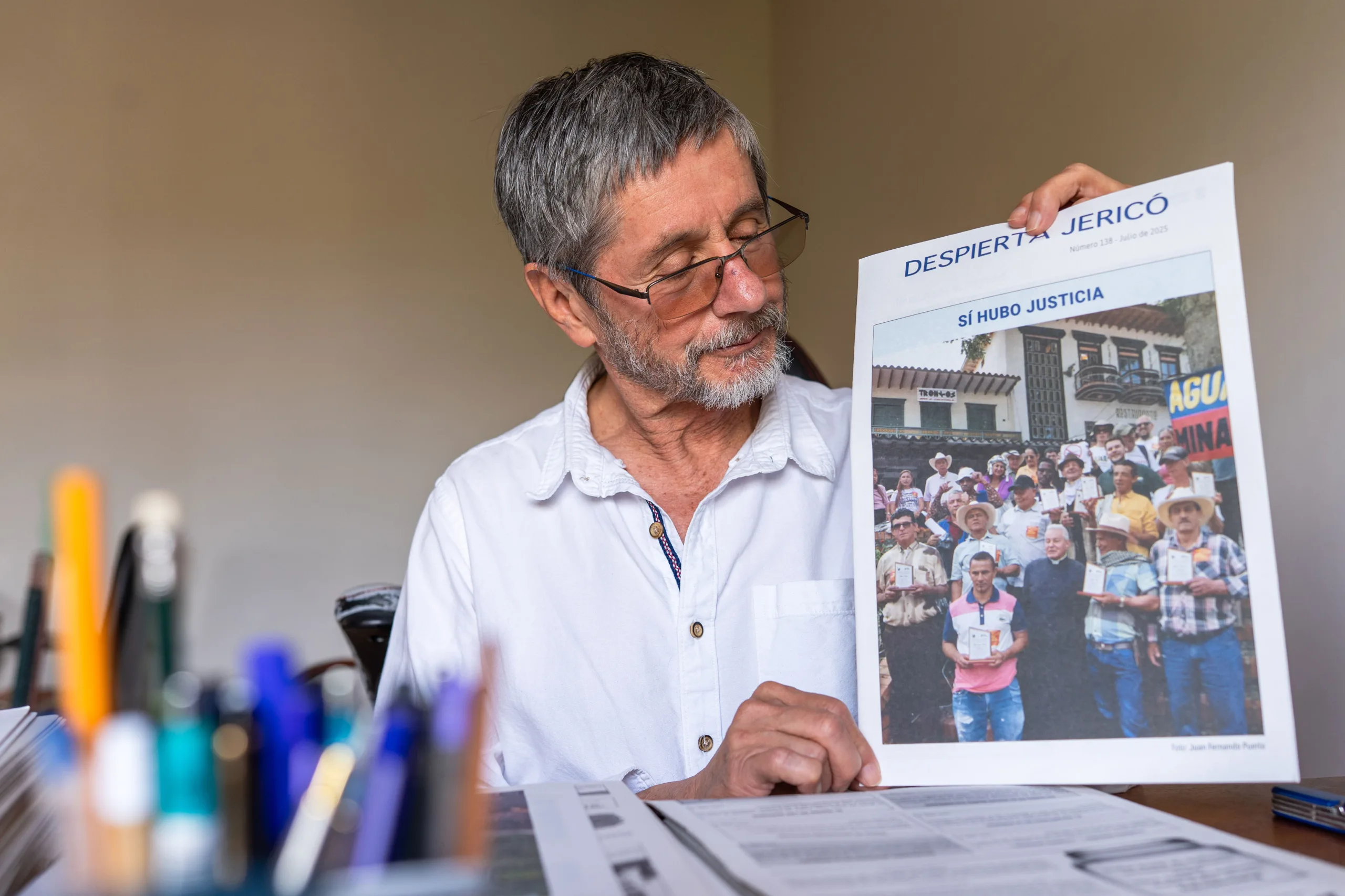 Fernando Jaramillo con la portada que Despierta Jericó dedicó a los 11 de Jericó, en julio de 2025. “Sí hubo justicia”, tituló el periódico en primera página, después de que el juez del caso decidiera que los once de Jericó podían continuar su defensa en libertad. Fotografía: Felipe Peláez. 